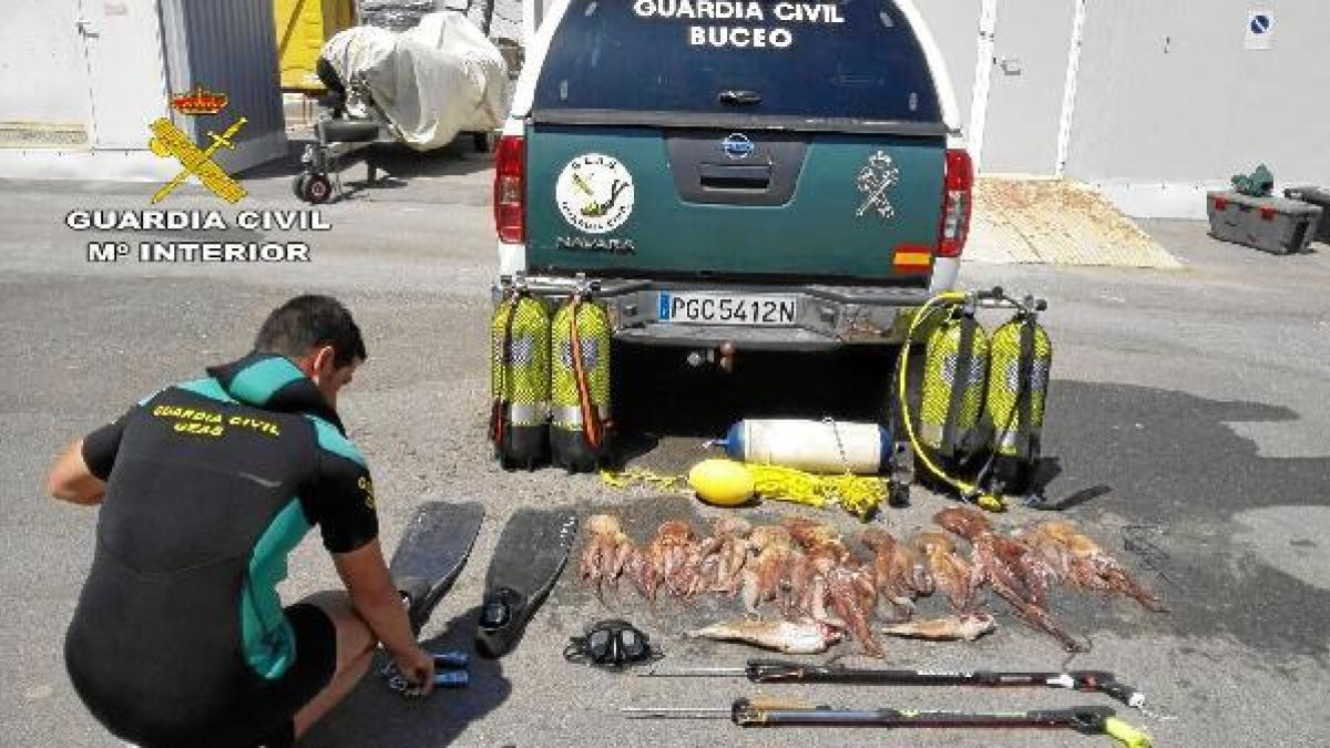 Un agente junto a los pulpos que habían pescado ilegalmente.