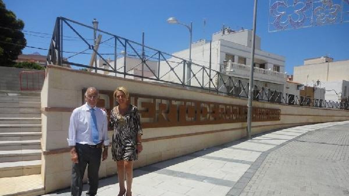 El alcalde y la concejal, ante el cartel que identifica al barrio.tyle>.apqj{position:abso