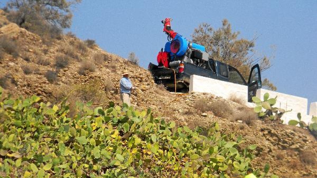Operarios fumigando en una zona de difícil acceso.e;clip:rect(4
