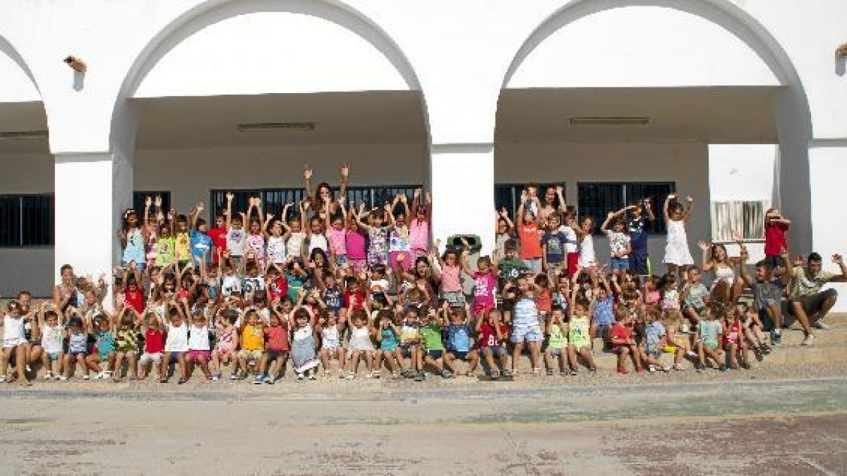 Alumnos y monitores de la escuela de verano de Carboneras saludan a las puertas de uno de los coleg
