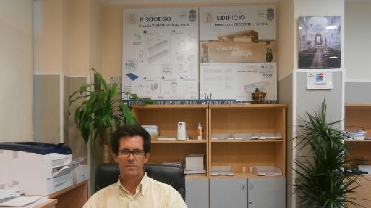 Eduardo Cano en la oficina. Detrás, los paneles explicativos de la potabilizadora.tyle>.ap