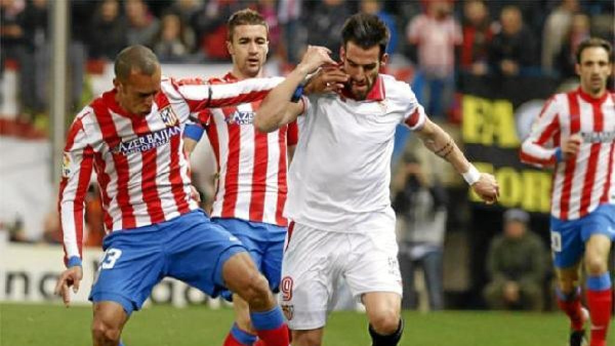 Álvaro Negredo con la camiseta del Sevilla jugando contra el Atlético.tyle>.apqj{position: