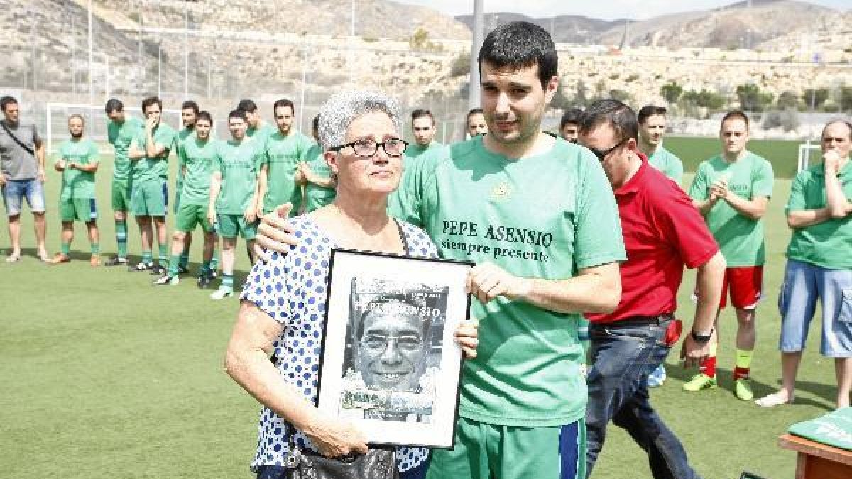 La viuda de Pepe Asensio con su hijo y una imagen del homenajeado.tyle>.apqj{position:abso