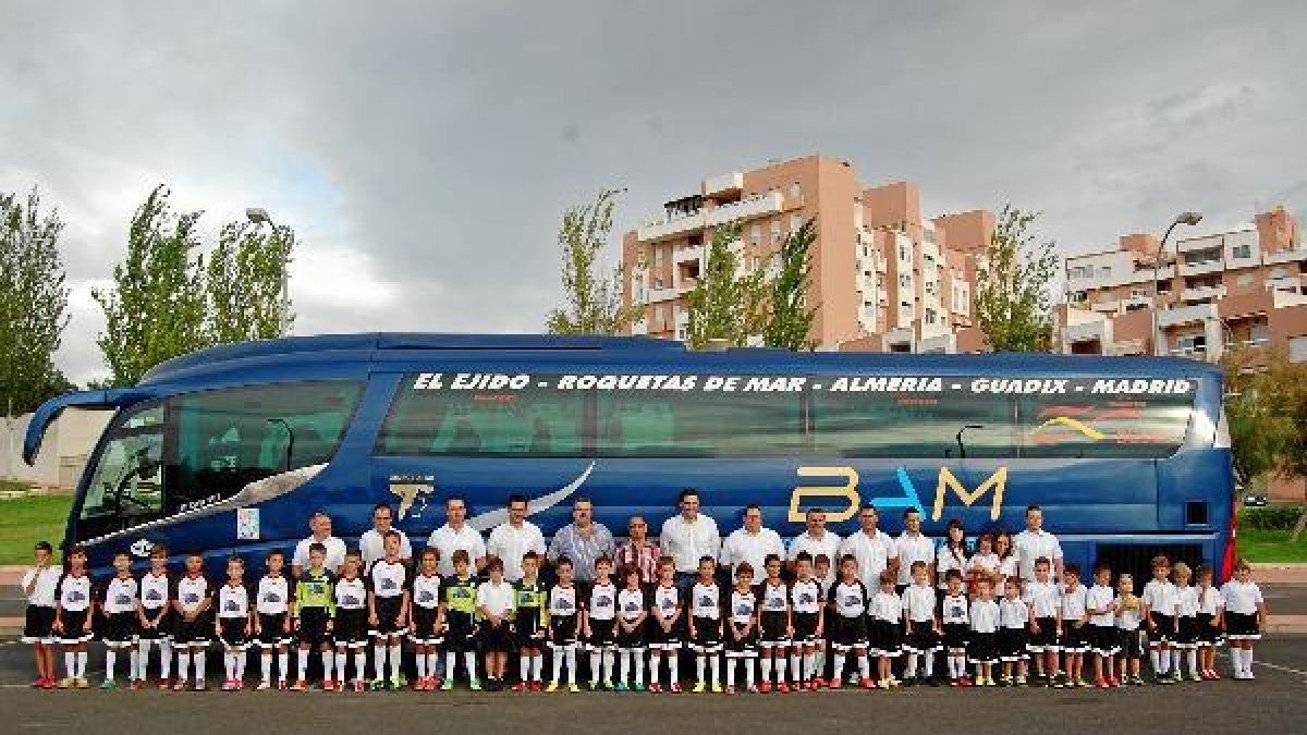 La gran familia del Busbam posa junto a uno de los vehículos del sponsor.tyle>.apqj{positi