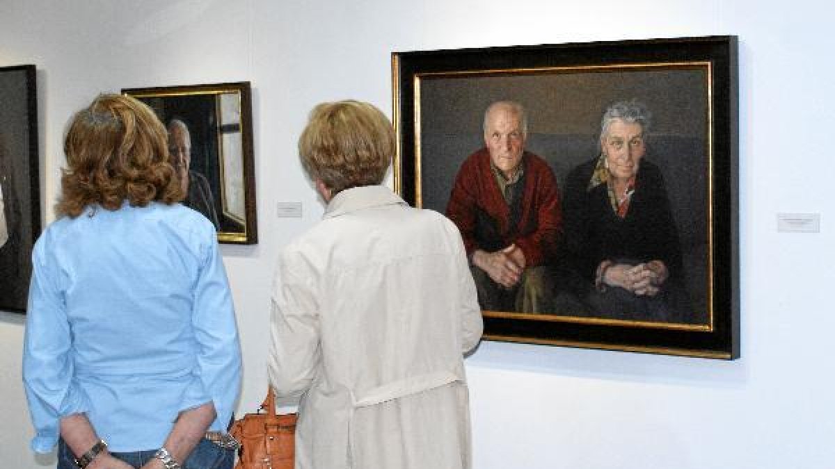 Visitantes admiran algunas obras de la exposición.e;clip:rect(4