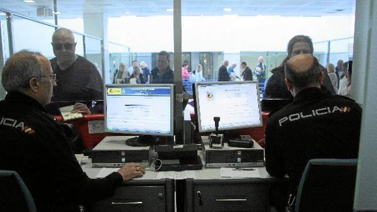 Agentes de la Policía controlan el pasaje de un vuelo de Monarch procedente de Birmingham. <