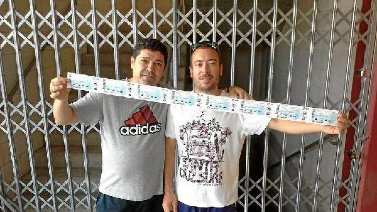Tres madrugadores pasan por la taquilla para conseguir sus entradas.tyle>.apqj{position:ab
