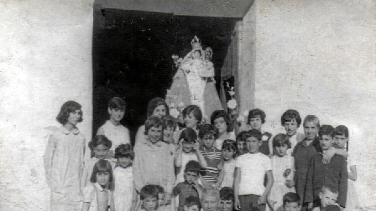 Vecinos junto a la Virgen de Patrocinio en la puerta de la iglesia de Olula de Castro. tyl