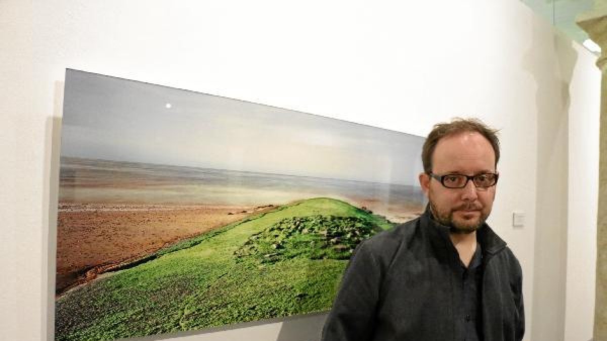 Eduardo Nave delante de una de las fotografías que expone en Almería.tyle>.apqj{position:a