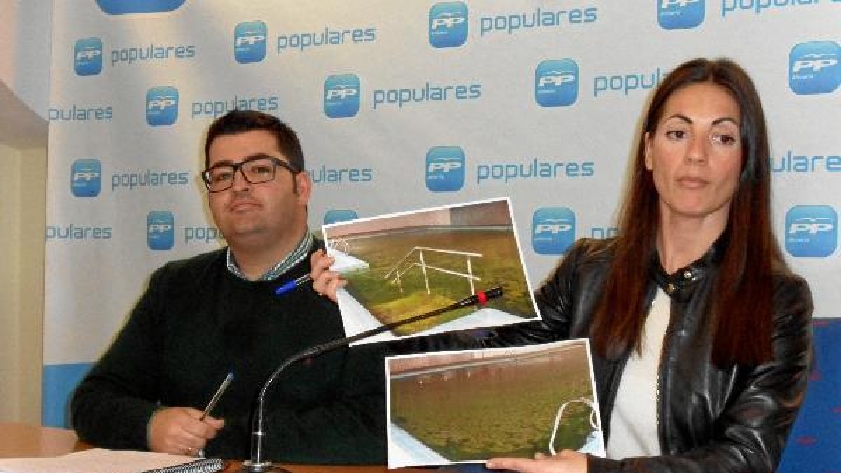 Rosario Soto sostiene fotos de la piscina llena de limo verde y abandonadatyle>.apqj{posit
