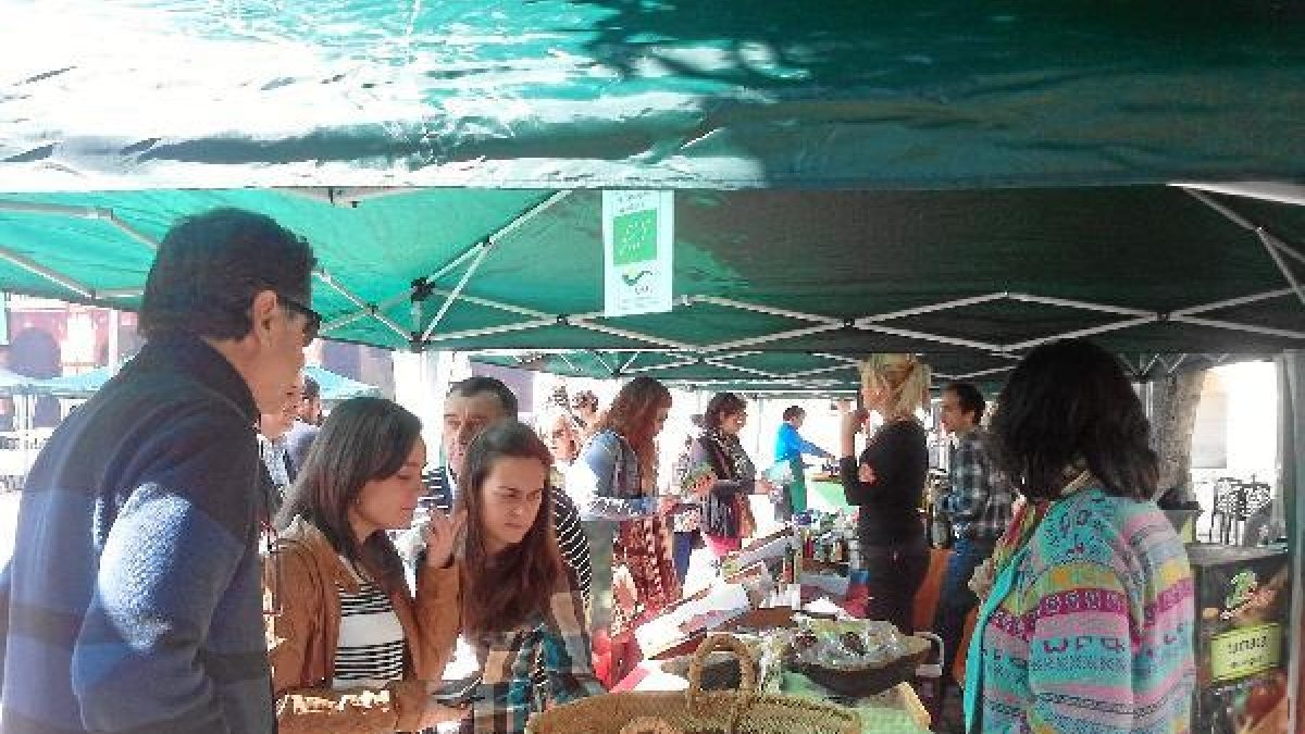 Una de las encargadas del Ecomercado atiende a unos clientese;c