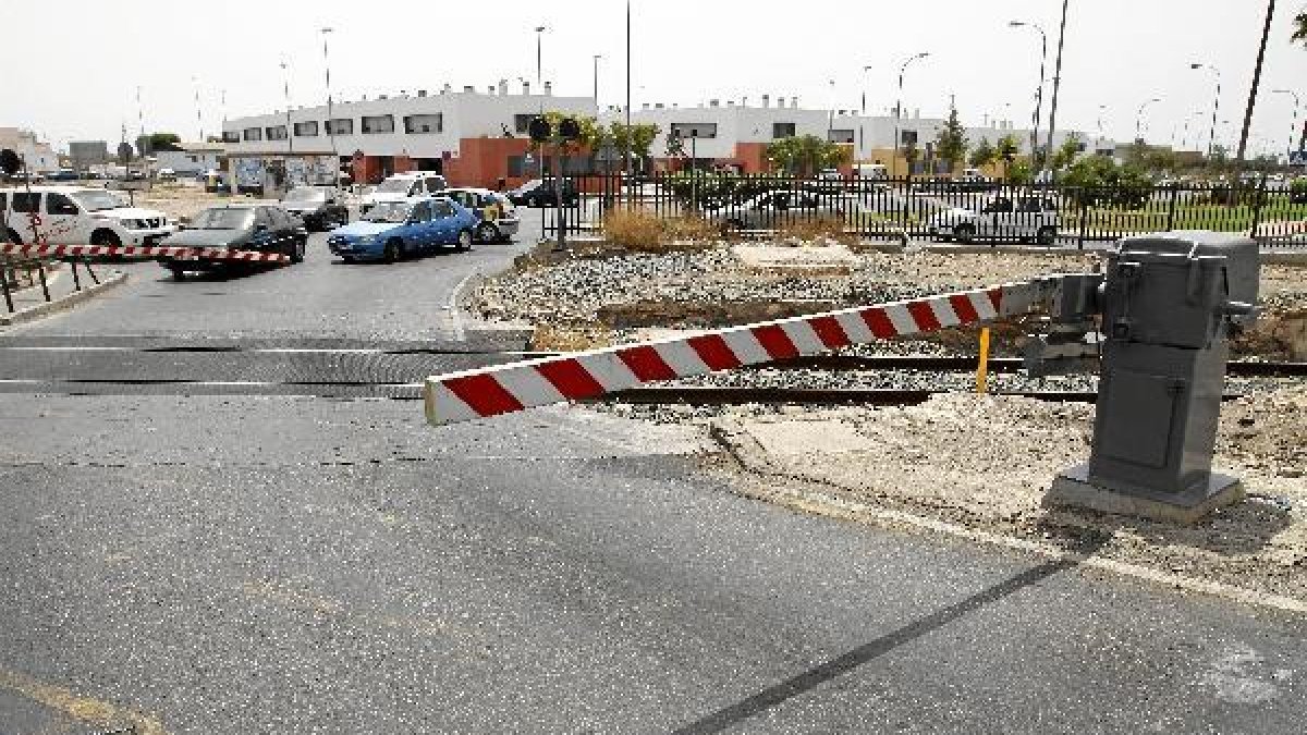 Imagen del paso a nivel de El Puche con las barreras bajadas esperando que pase el ferrocarril.