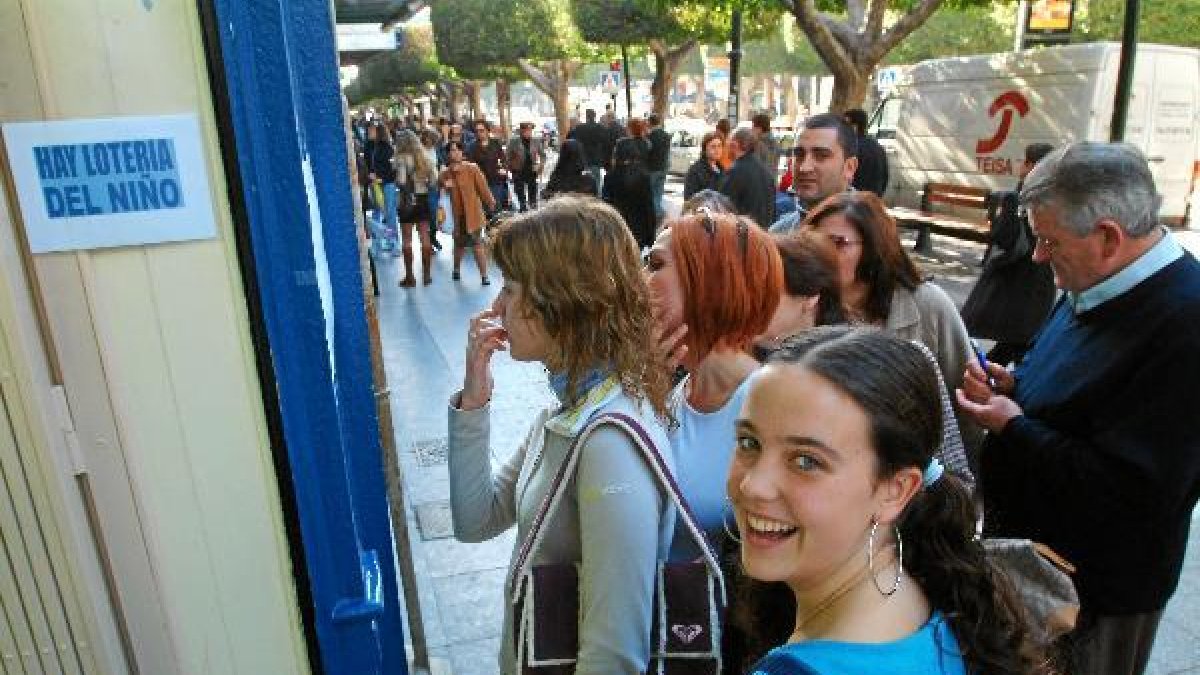 Un gripo de personas hace cola ante una administración almeriense para comprar lotería en una imagen