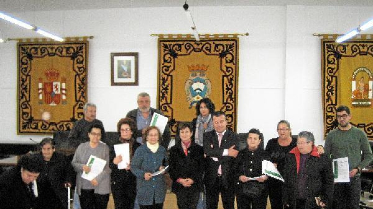 Autoridades posan con las familias beneficiarias de las ayudas.