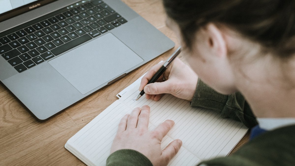 Estudiante escribiendo en su cuaderno.