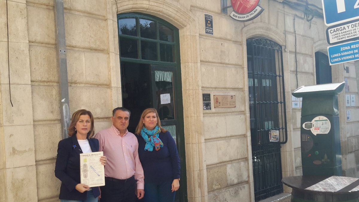 La propietaria junto a los dueños del bar.