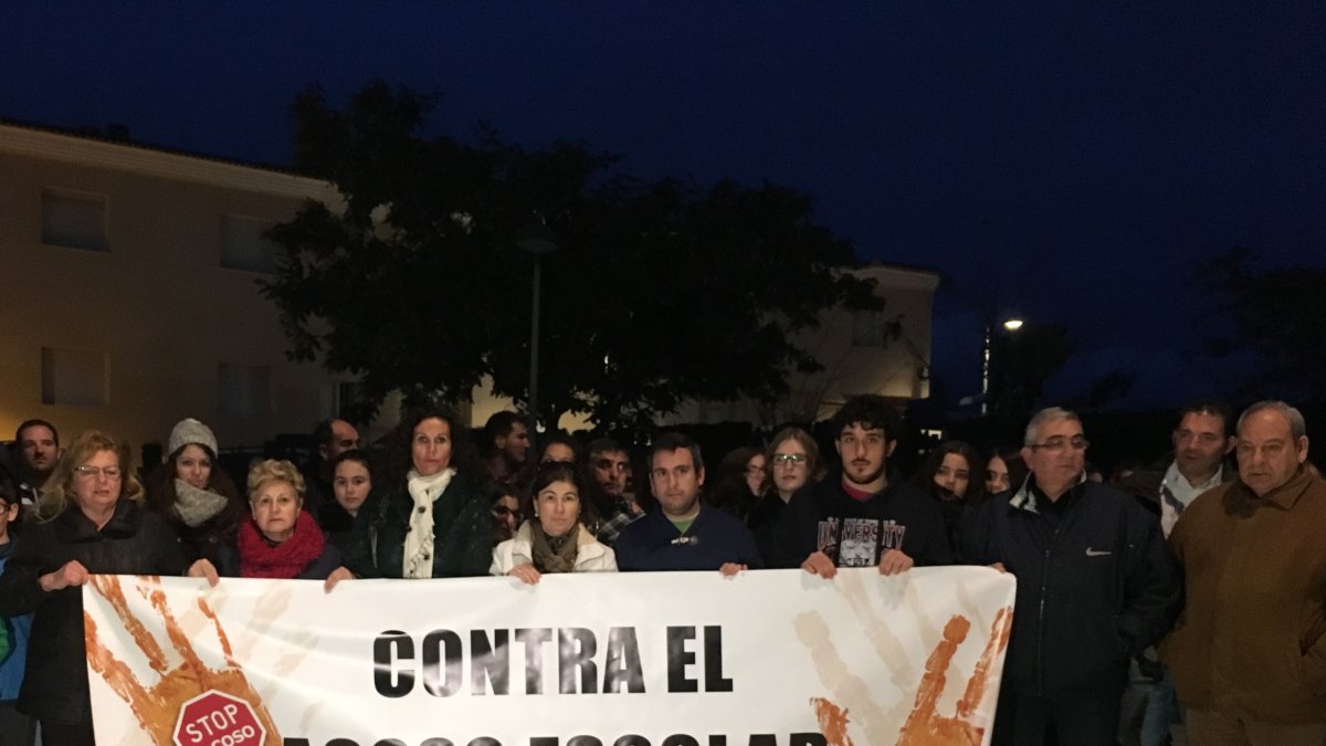 Asistentes a la concentración tras la pancarta con el lema de la misma ‘Stop Acoso’.