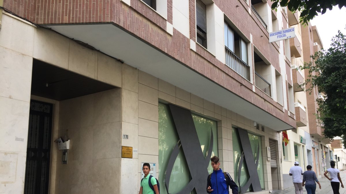 Dos adolescentes pasan por delante del portal donde vivía la familia