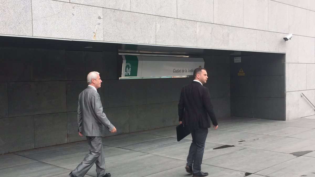 Demetrio Carmona (gris) saliendo esta mañana de los juzgados