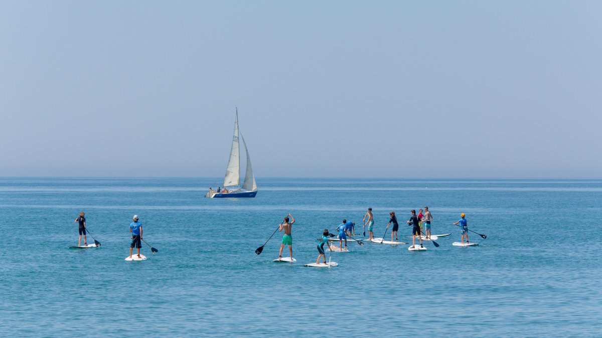 Turistas hacen paddle surf en la playa de Almerimar.