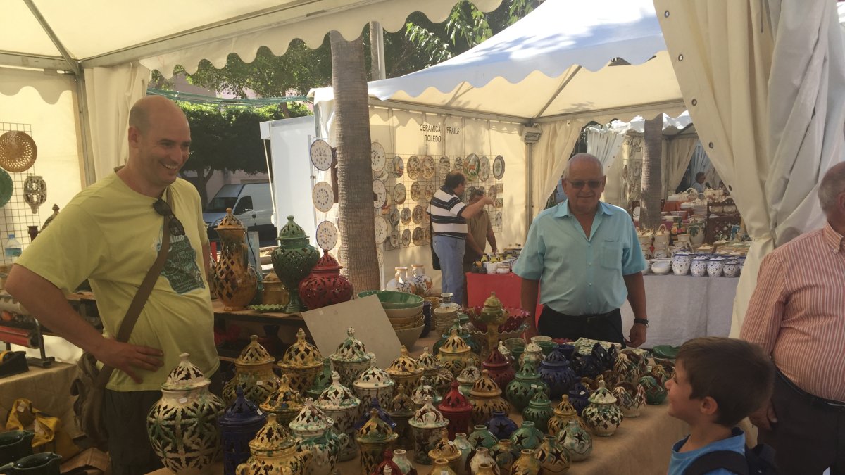Un pequeño se acerca al expositor de un artesano de Jaén.