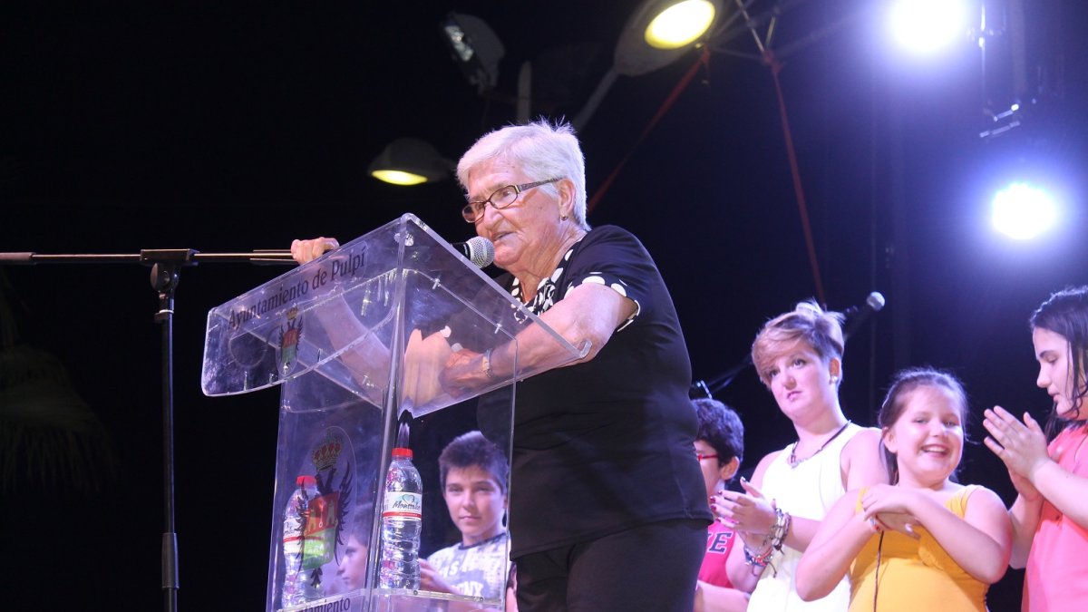 Josefa López, aplaudida por sus nietos, durante la lectura del pregón en Terreros.