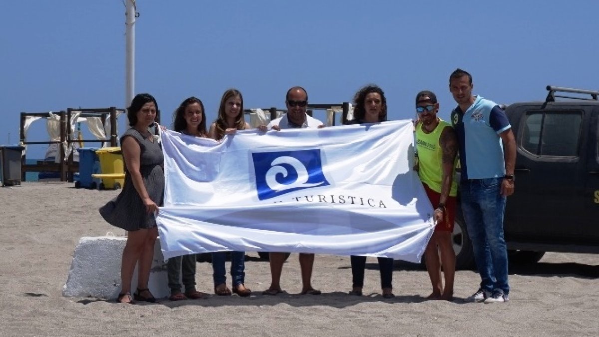 Concejales y técnicos con la bandera de calidad turística.