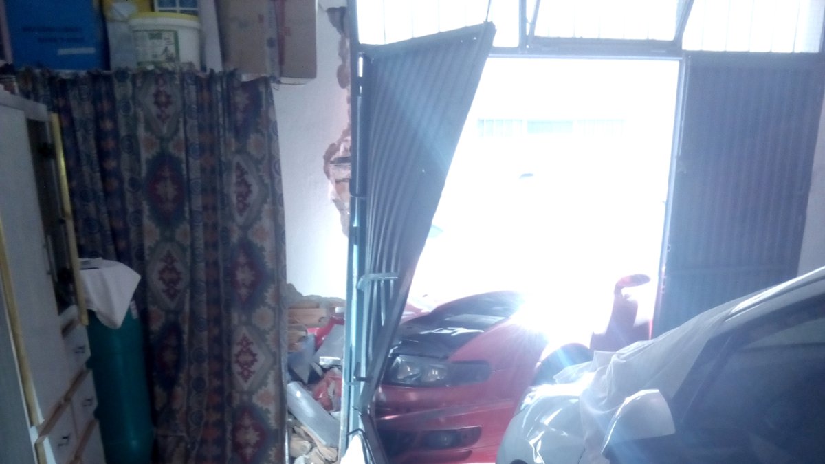 El vehículo se empotró en la cochera de una vivienda.
