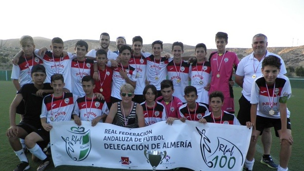 Los campeones con los trofeos posan con la pancarta federativa.