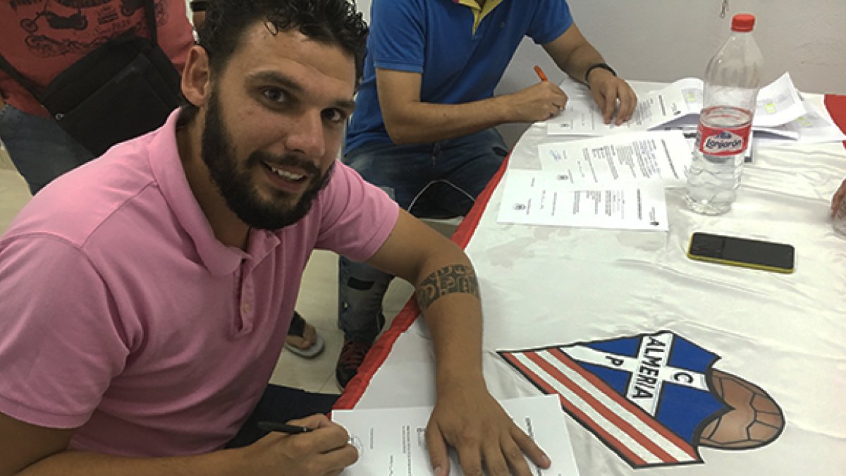 El míster, firmando.