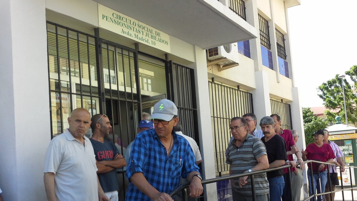 Usuarios del centro social de jubilados de las 500 Viviendas en la barandilla de la entrada.