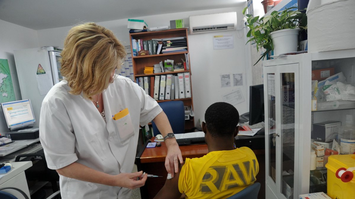 Una sanitaria vacuna a un viajero en una imagen de archivo.