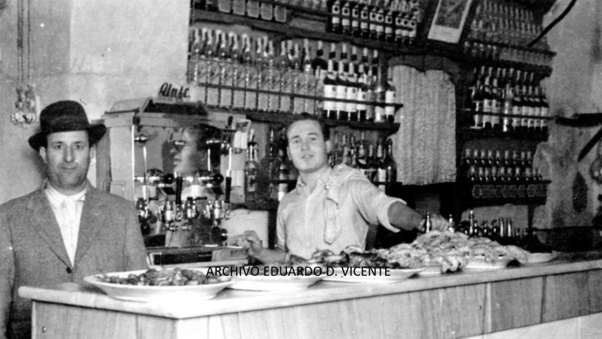 josé Murcia Moya, fundador y dueño del bar ‘El Cuco’, aparece detrás del mostrador con un sombrero oscuro en una imagen de 1945. A su lado está su hi