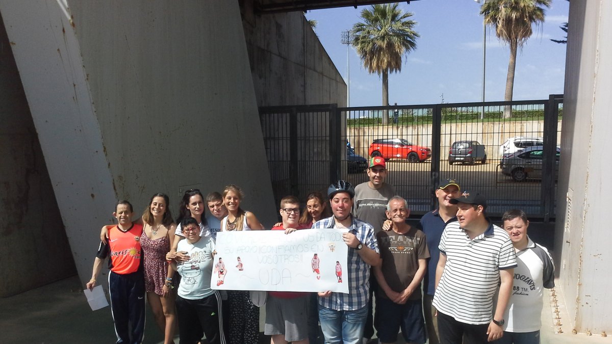 Con pancartas de apoyo al equipo en el entrenamiento.