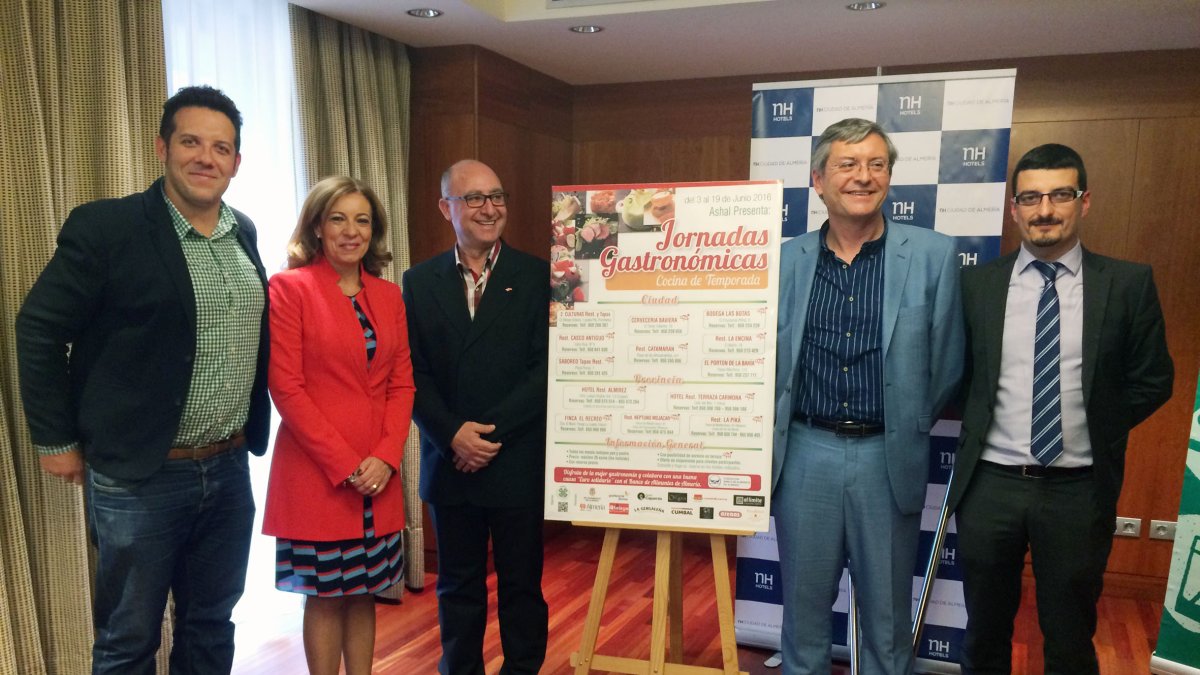 Junto al cartel de las jornadas, promotores y organizadores del evento.