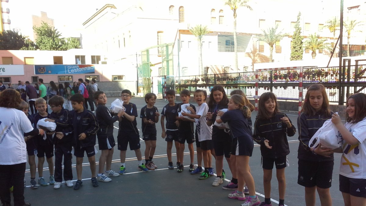 Los alumnos del centro educativo se van pasando los alimentos.