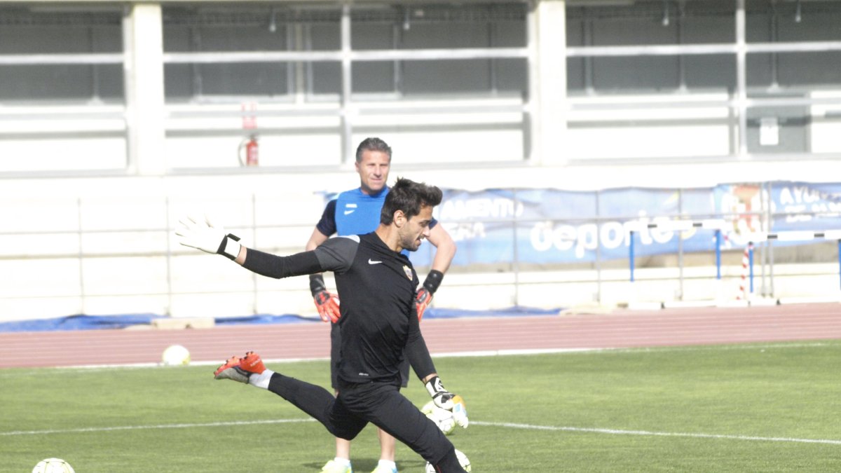 Casto golpea el balón junto a Ángel Férez.