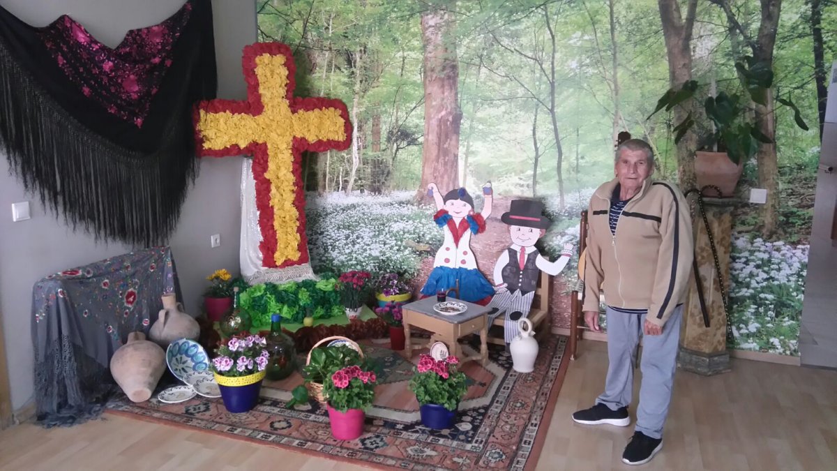 Un residente posa junto a la cruz ganadora.