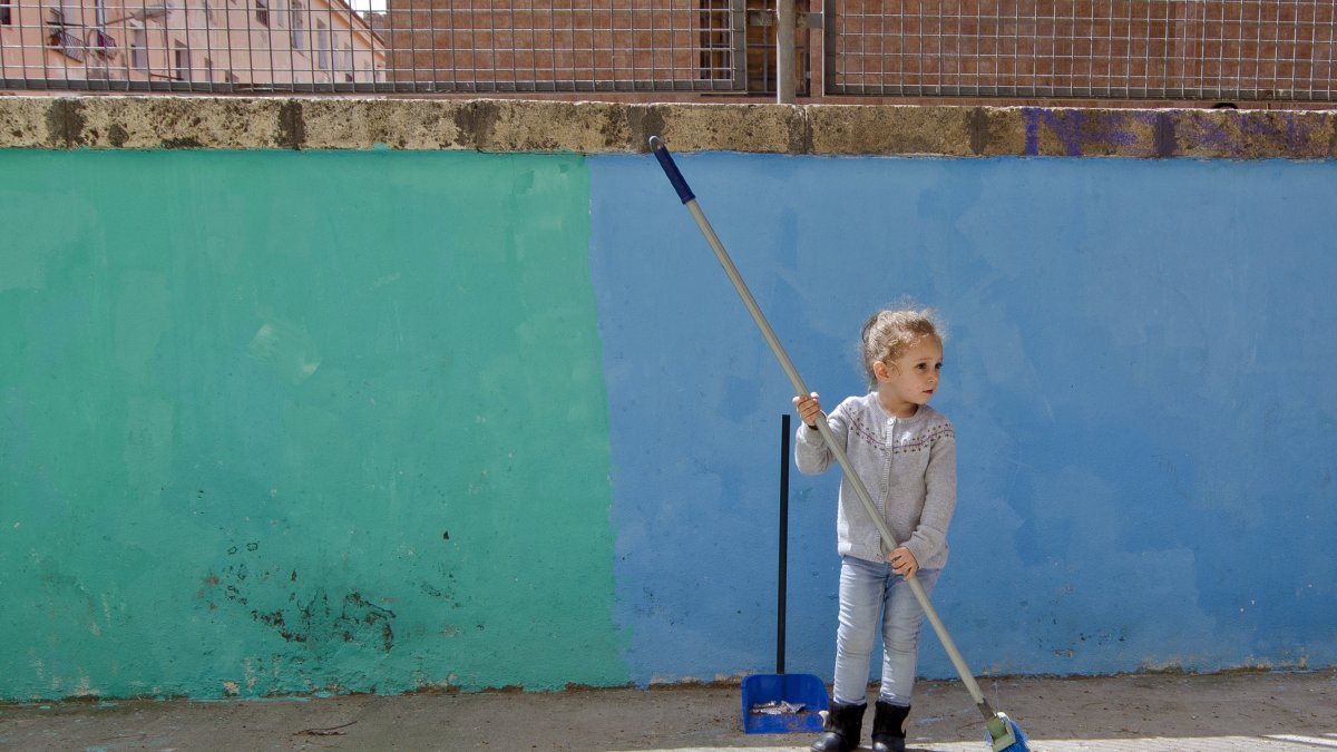 Una niña barre la calle de La Chanca, donde es ‘cazada’ por el fotógrafo.