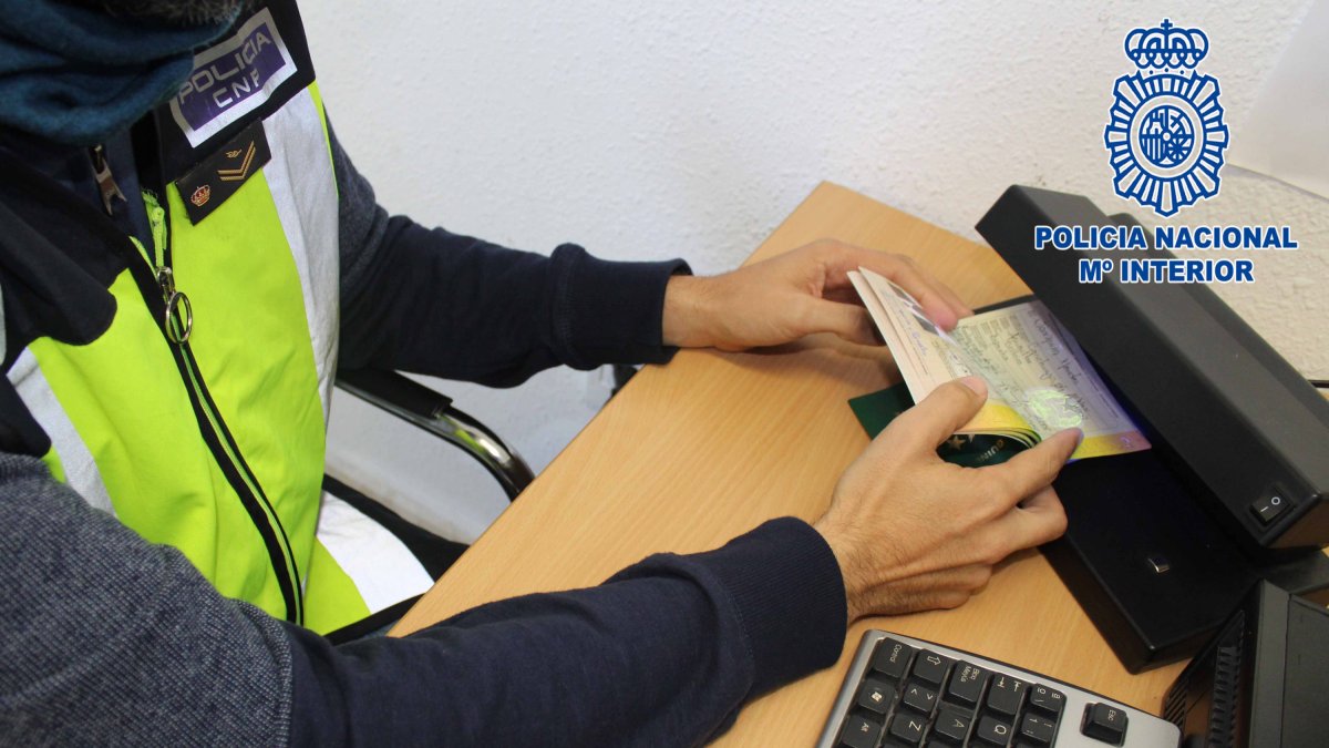 Un agente de la Policía Nacional comprobando un pasaporte.