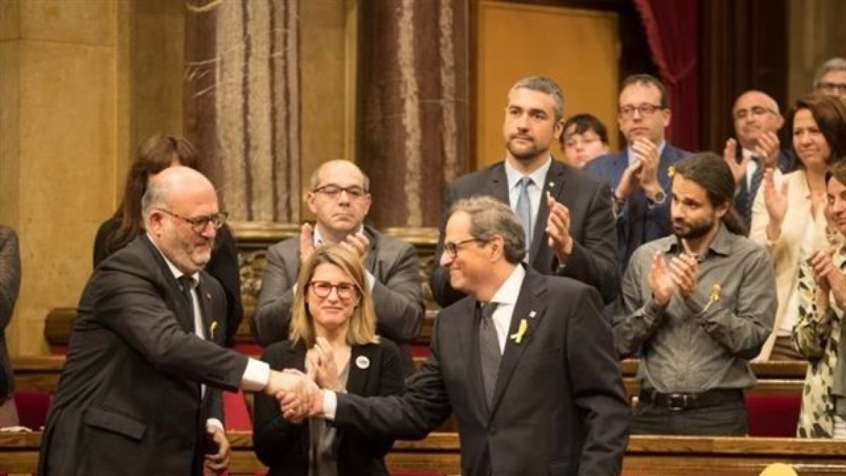 Quim Torra saluda a diputados de JxCat en la segunda sesión del pleno. (Foto: Parlament)