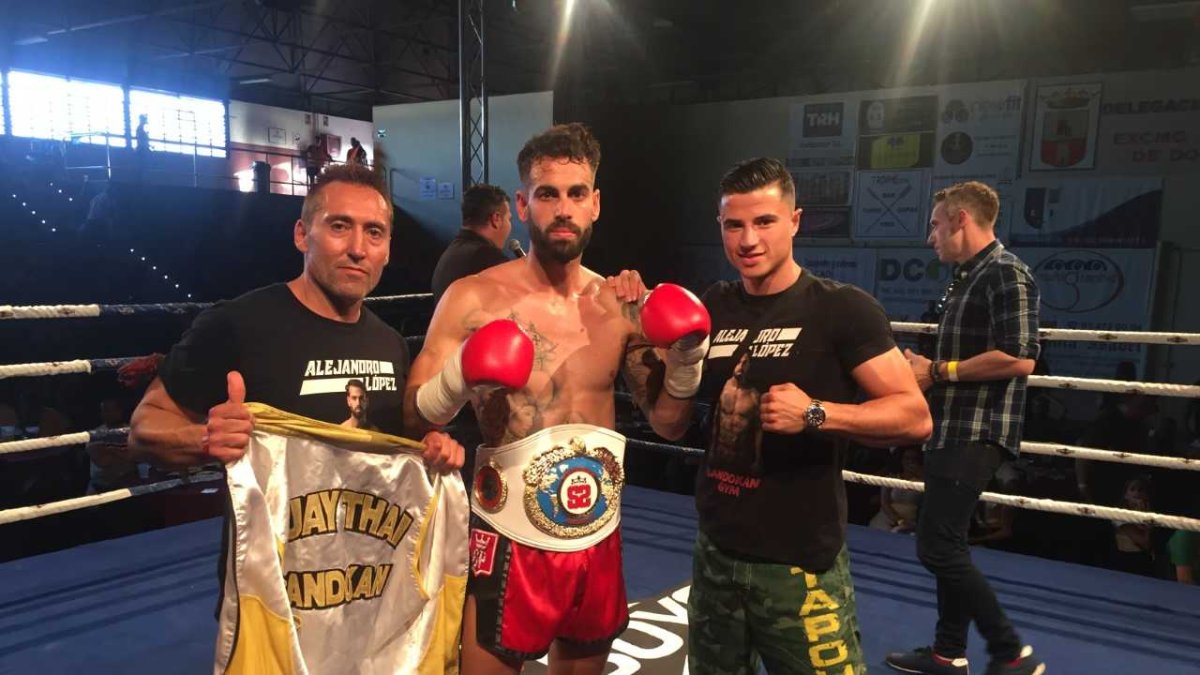 El campeón con su premio posa con los entrenadores.