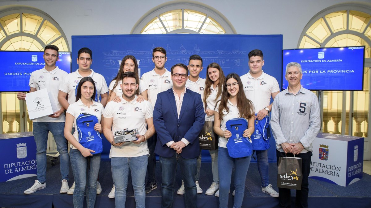 Los jóvenes integrantes del equipo de robótica y su profesor (derecha) con el diputado provincial (centro).