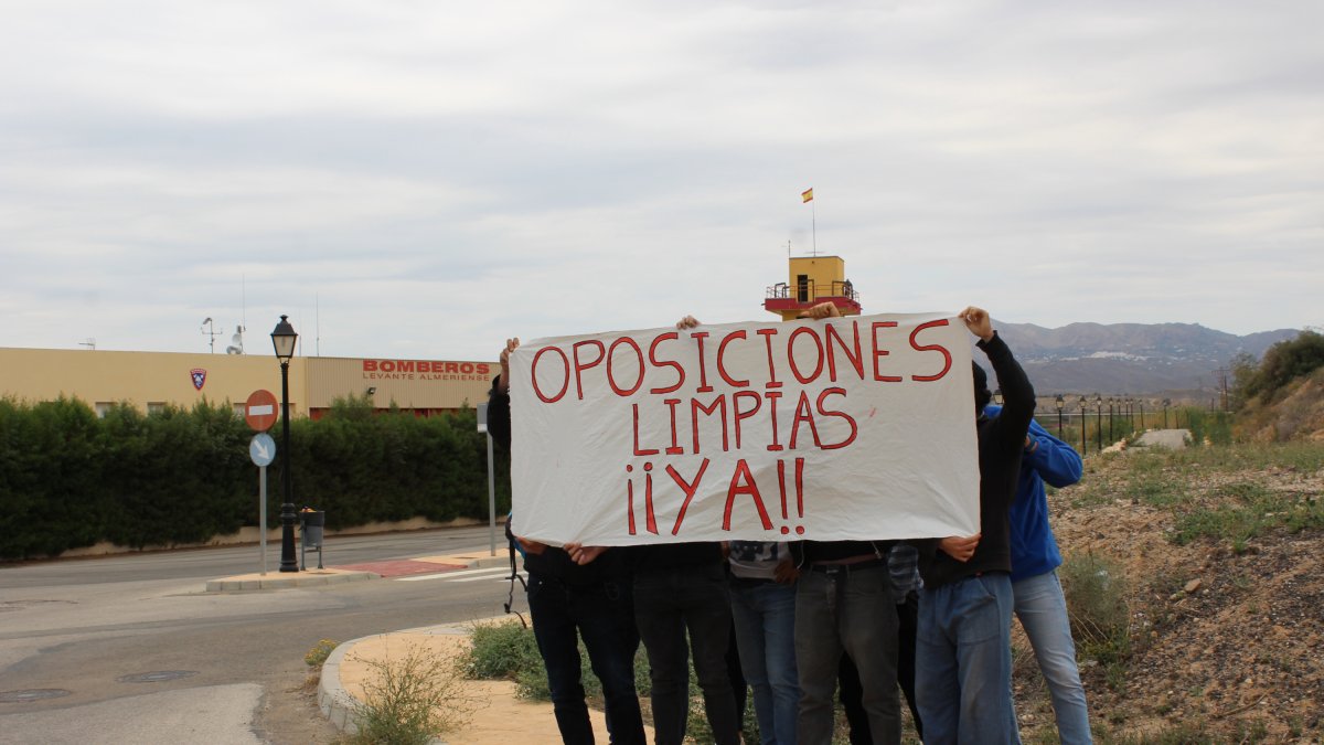 Un grupo de opositores reclaman unas oposiciones limpias frente al parque de bomberos.