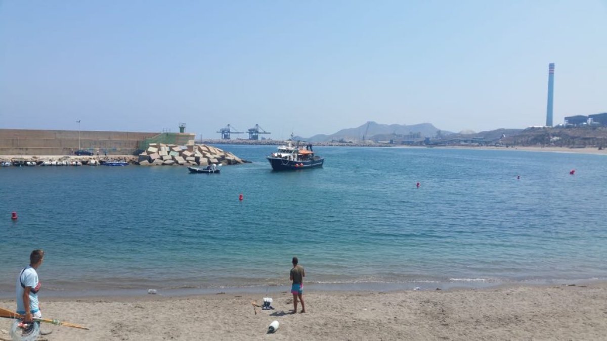 El barco de cerco en el momento del remolque por el bote lucero en la bocana de Carboneras.