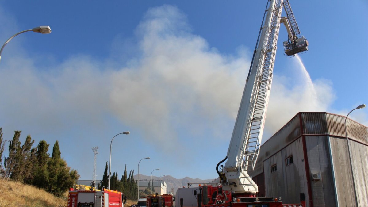 Bomberos del Poniente durante las tareas de extinción del incendio en una nave en Adra.