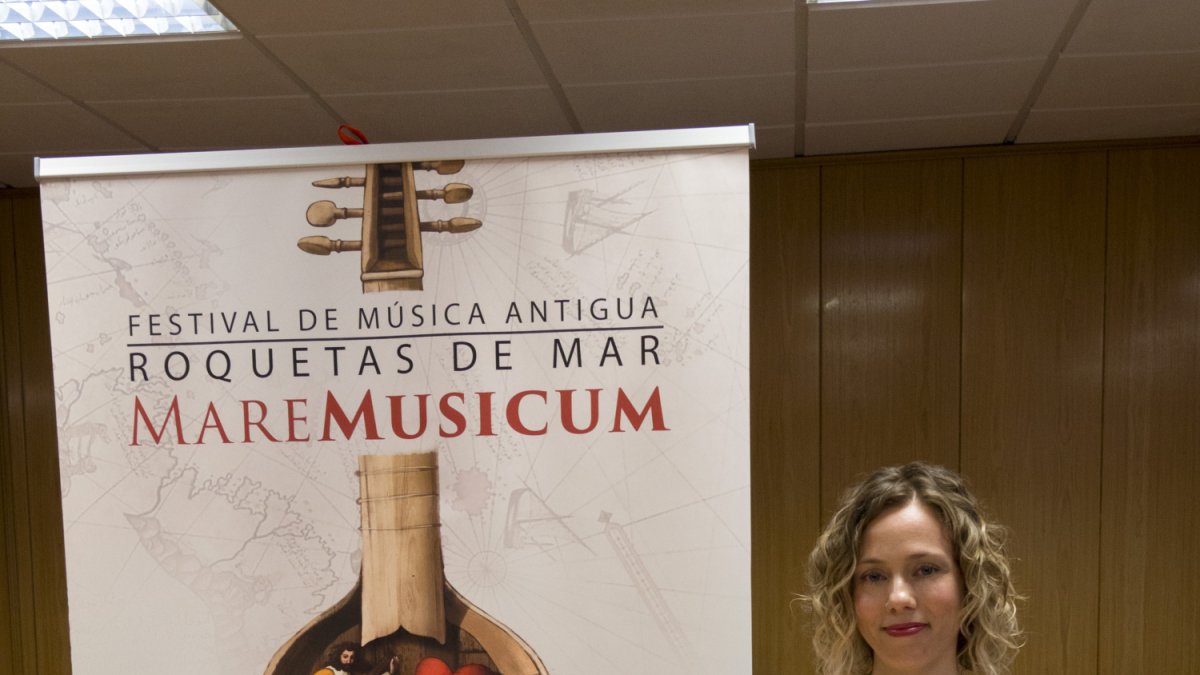Belinda Sánchez-Capuchino junto al cartel del festival, obra de Emilio Villalba.