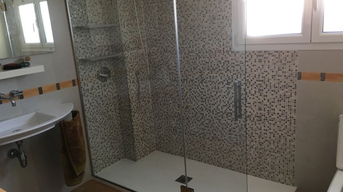 Ducha nueva ocupando el hueco de una antigua bañera.