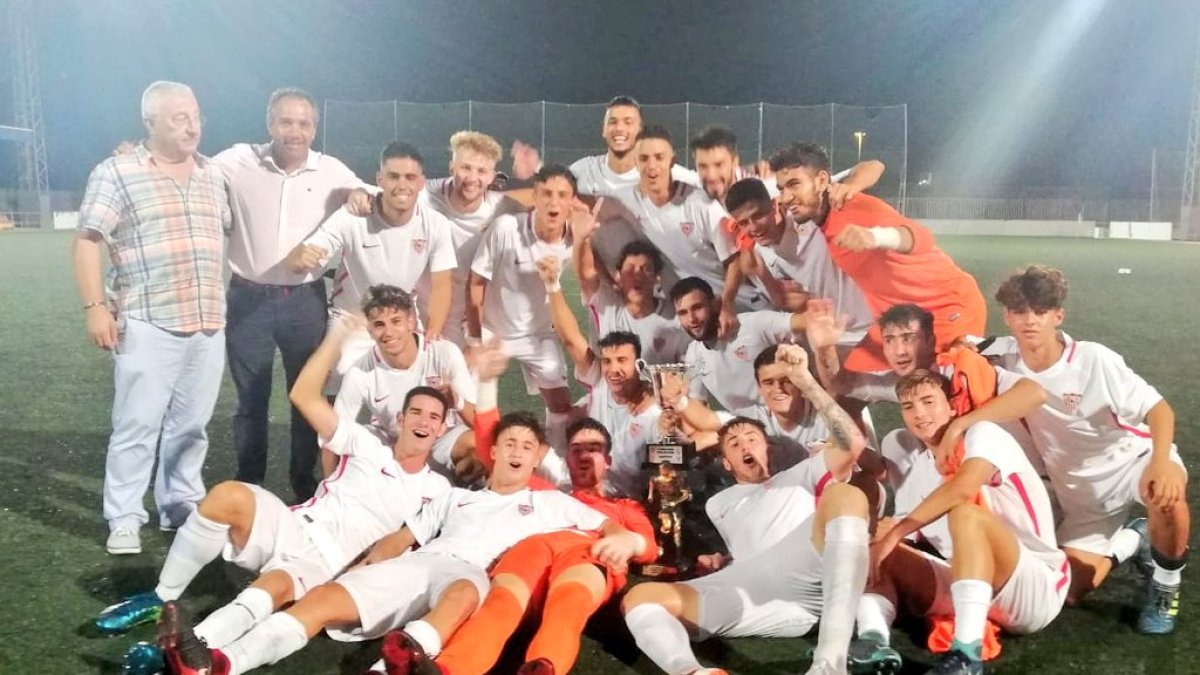 Los canteranos del Sevilla celebran sobre elk césped.