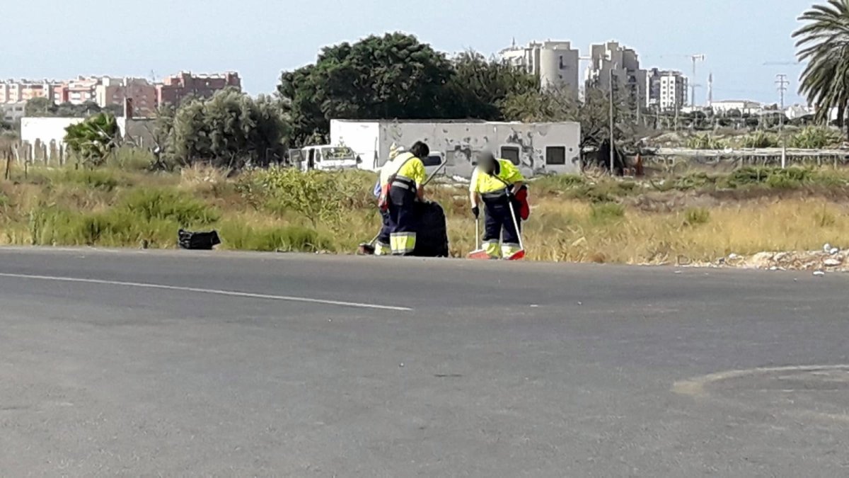 Trabajadores del plan limpiando el arcén de una vía